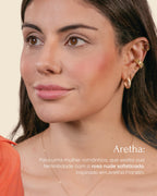 Mulher usando blush multifuncional nos lábios, olhos e bochechas, resistente à água e ao suor, vegano e sem parabenos. 