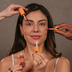Mulher aplicando blush multifuncional nos olhos, lábios e bochechas. Resistente á água e ao suor, vegano, sem parabenos.